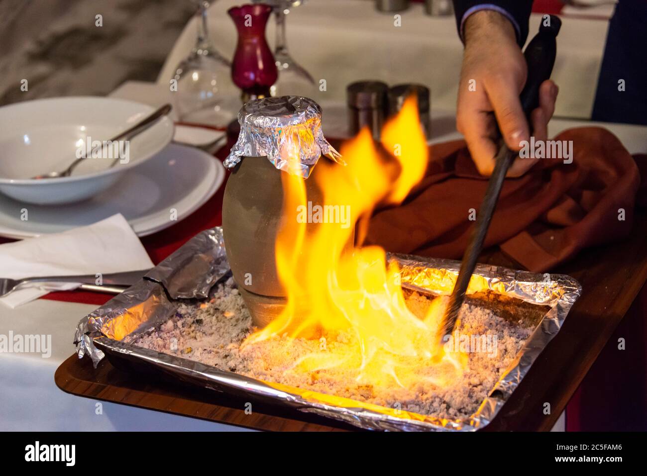 Testi Kebab is served with fire in a restaurant, Kebab braised in an earthenware pot, typical Turkish dish from Cappadocia, Istanbul, Turkey Stock Photo