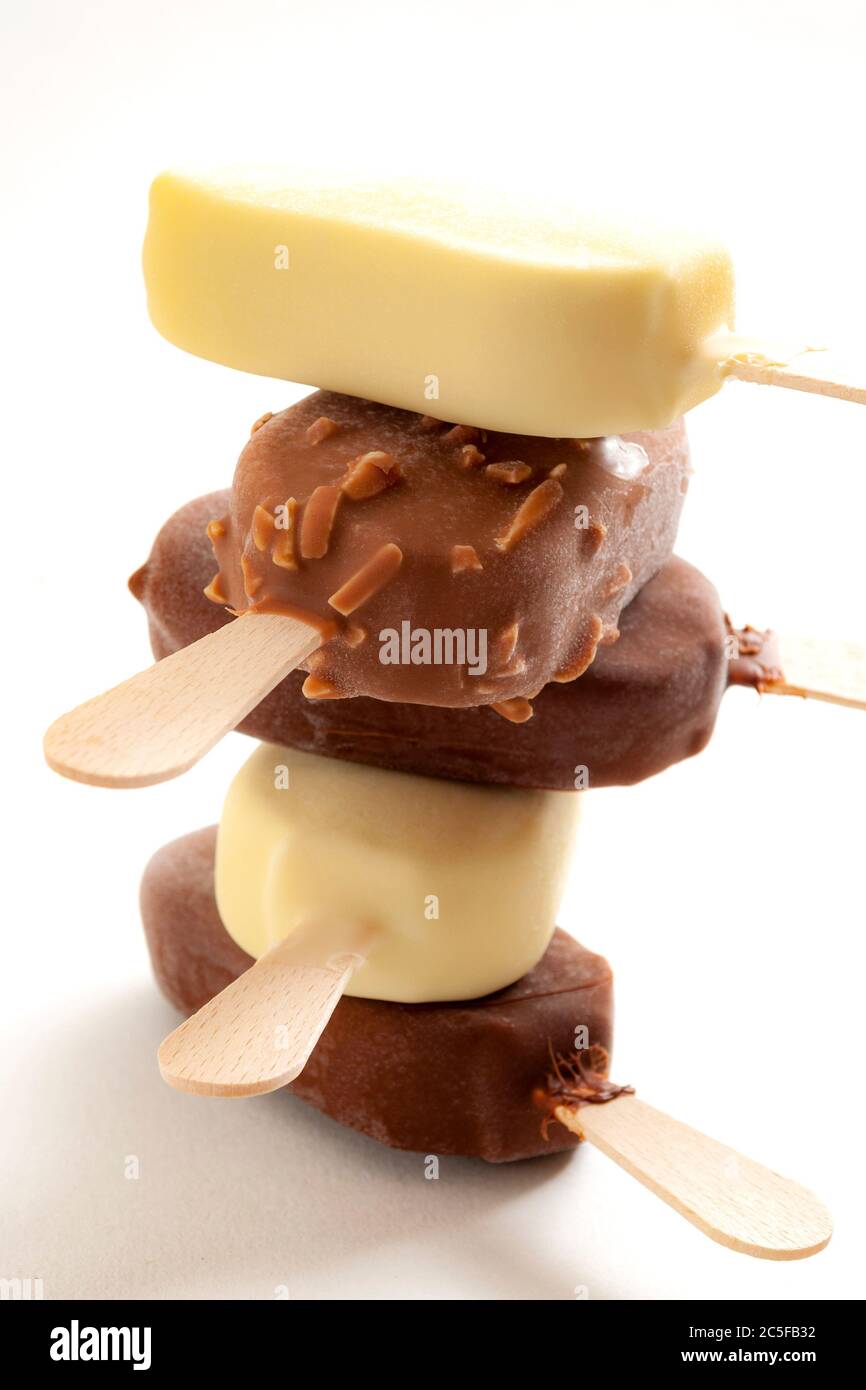Refreshing summer food, icy cold dessert and frozen snack concept with close up on stack of sweet ice cream bars coated in milk chocolate and hazelnut Stock Photo