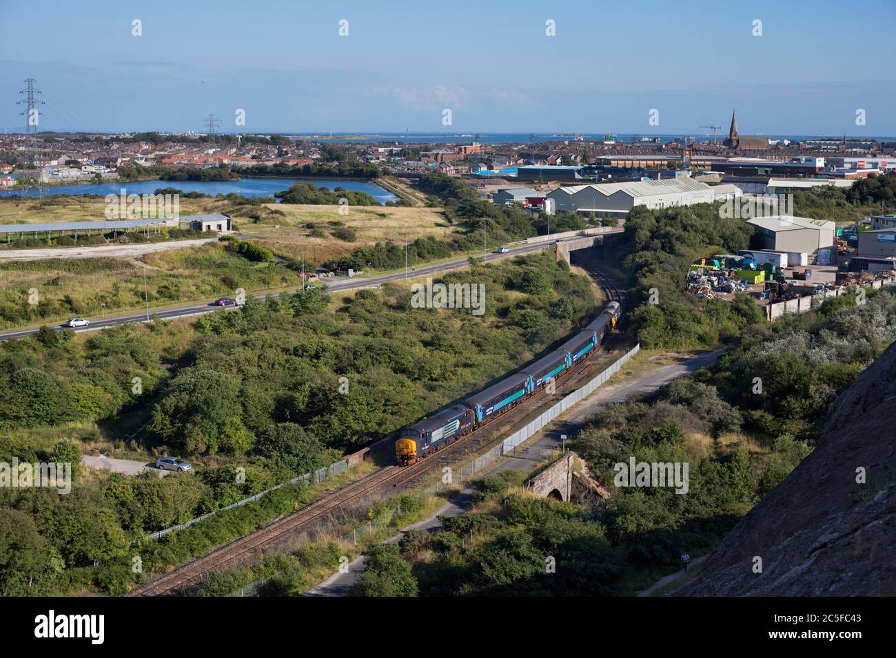 Direct Rail Services class 37 locomotive 37409 departing from Barrow In Furness with a Northern Rail passenger train Stock Photo