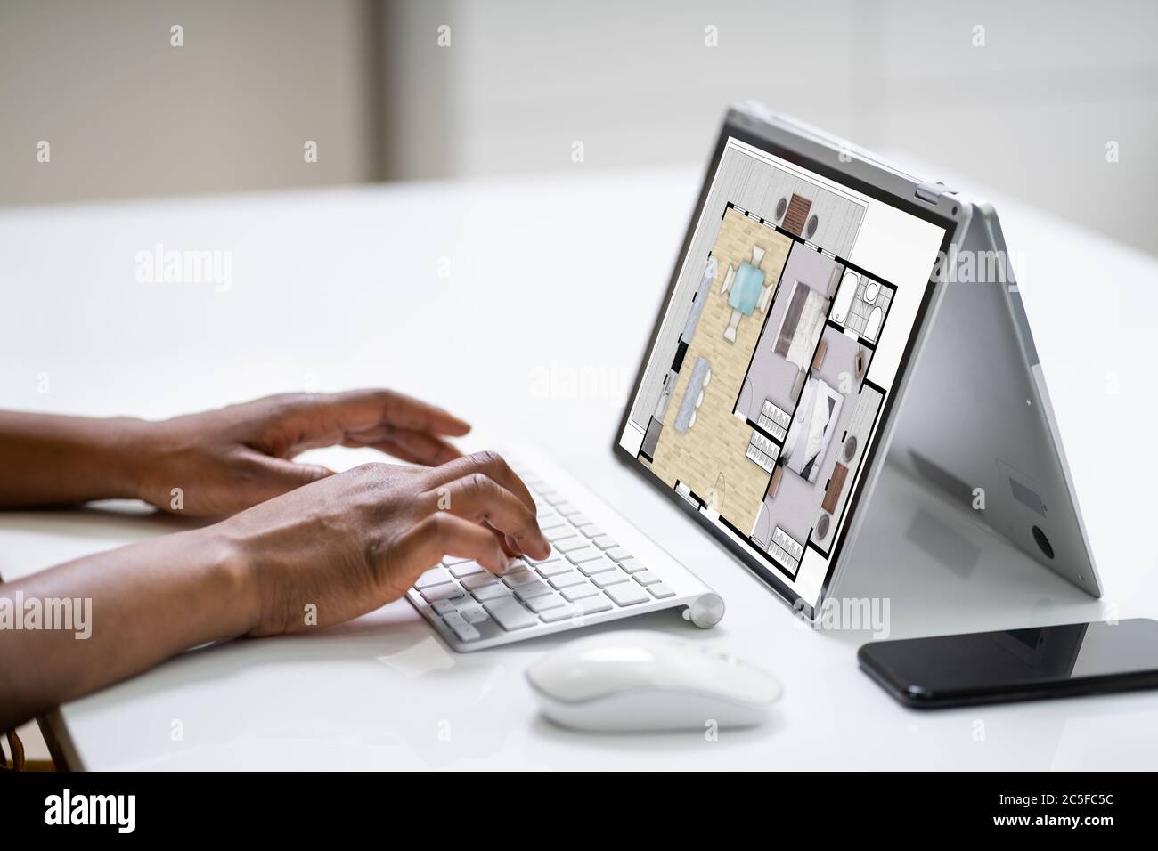 African Construction Engineer Using Laptop In Office Stock Photo