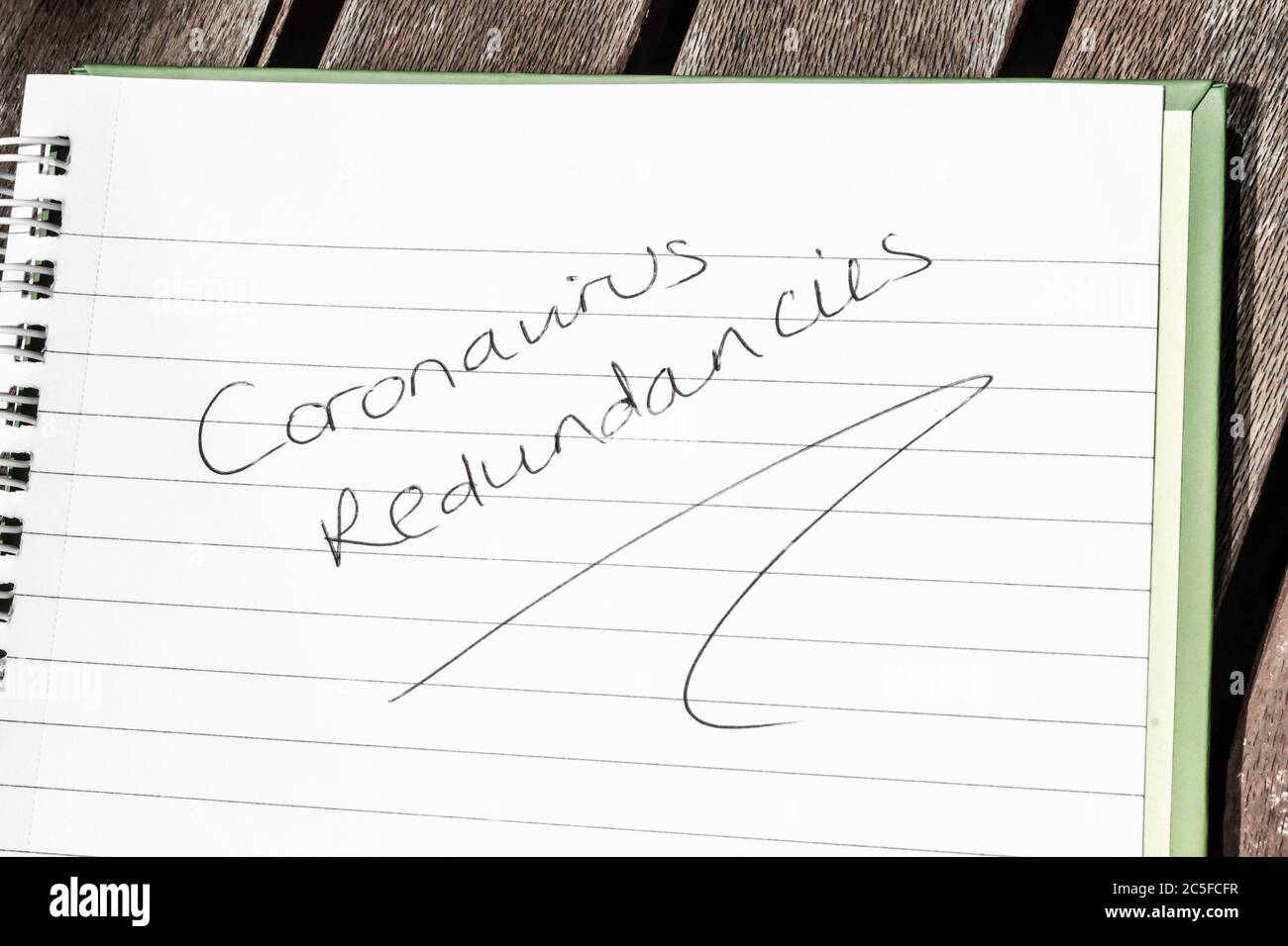 CORONAVIRUS REDUNDANCIES written on lined paper Stock Photo