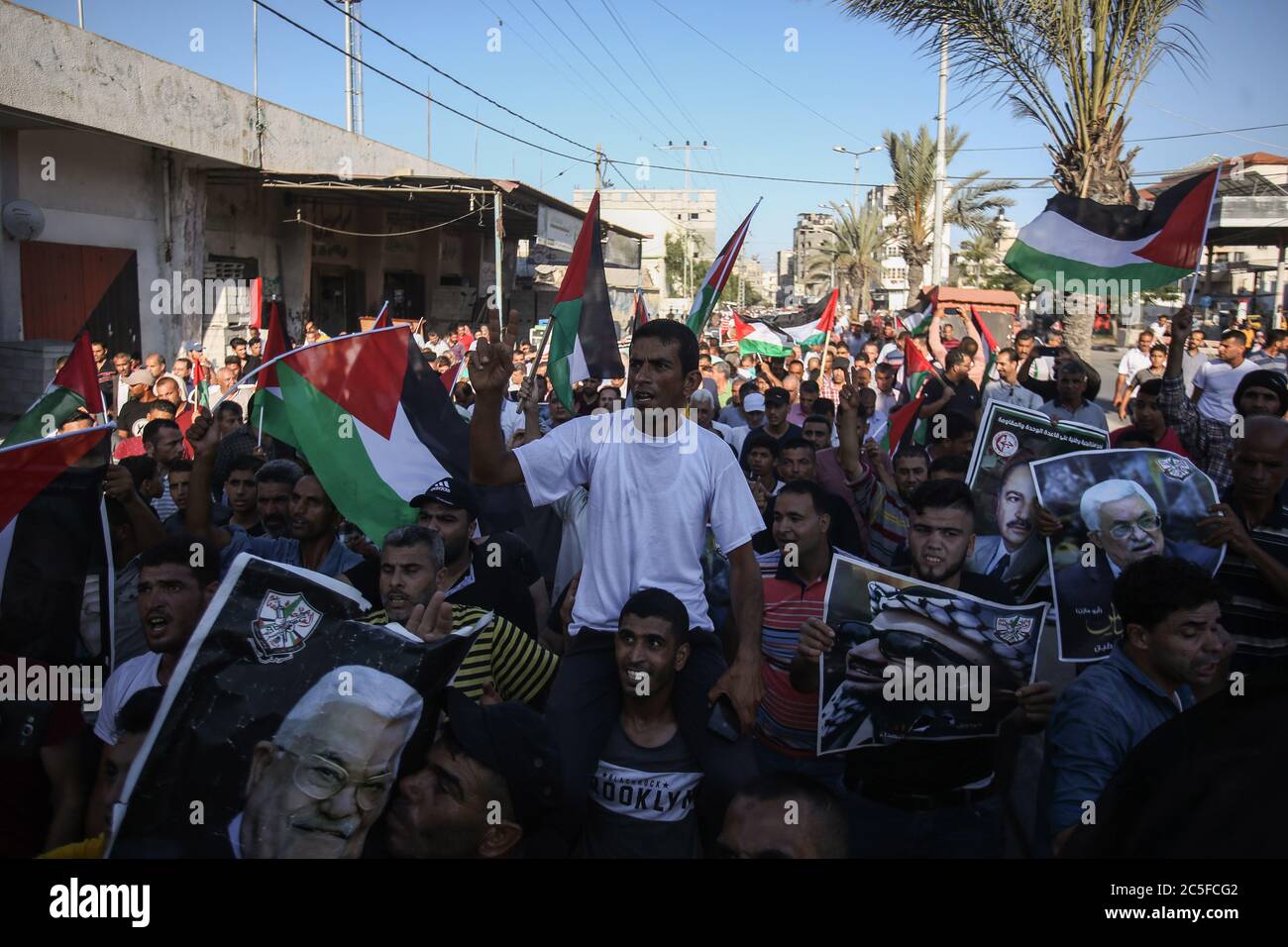 Demonstrators chant slogans while carrying placards of the late Palestinian President Yasser Arafat during a demonstration against Israeli plans to annex parts of the occupied West Bank in the central Gaza Strip. Stock Photo