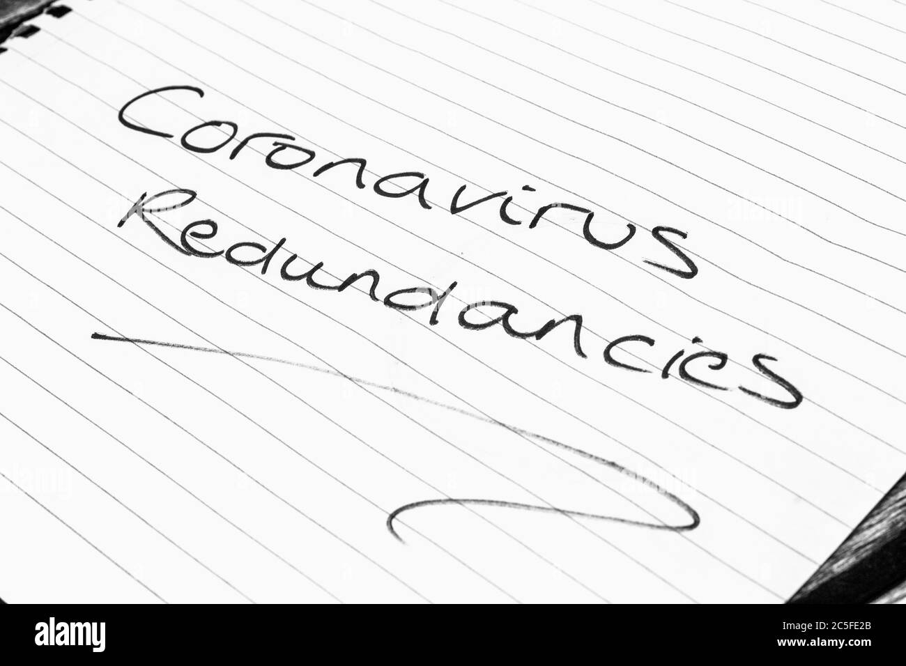 CORONAVIRUS REDUNDANCIES written on lined paper Stock Photo