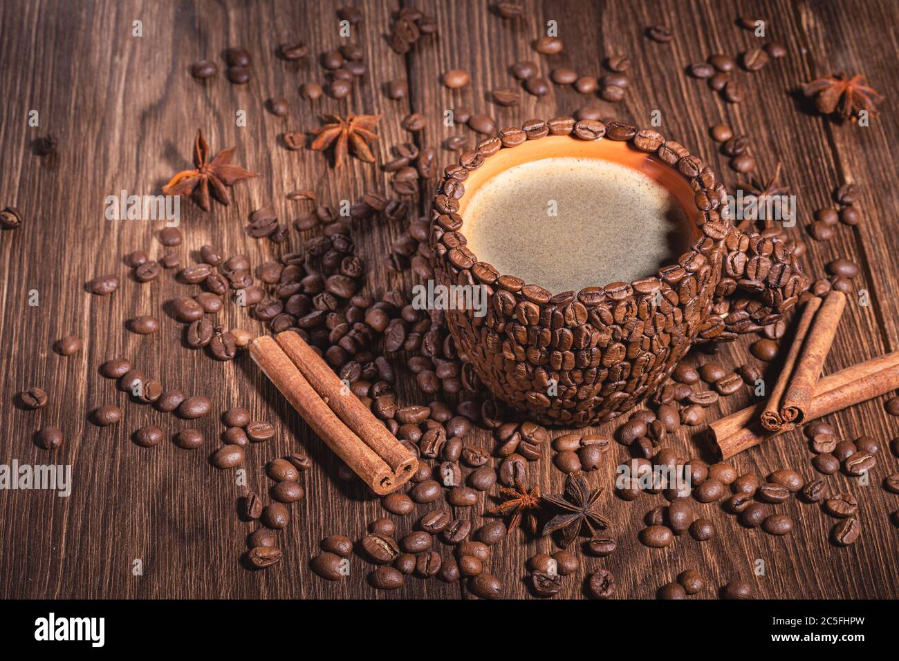 Coffee cup with coffee made from coffee beans wooden table Copy space. Coffee Cup Table Wood Grain coffee Side view Cinnamon stick. Stock Photo