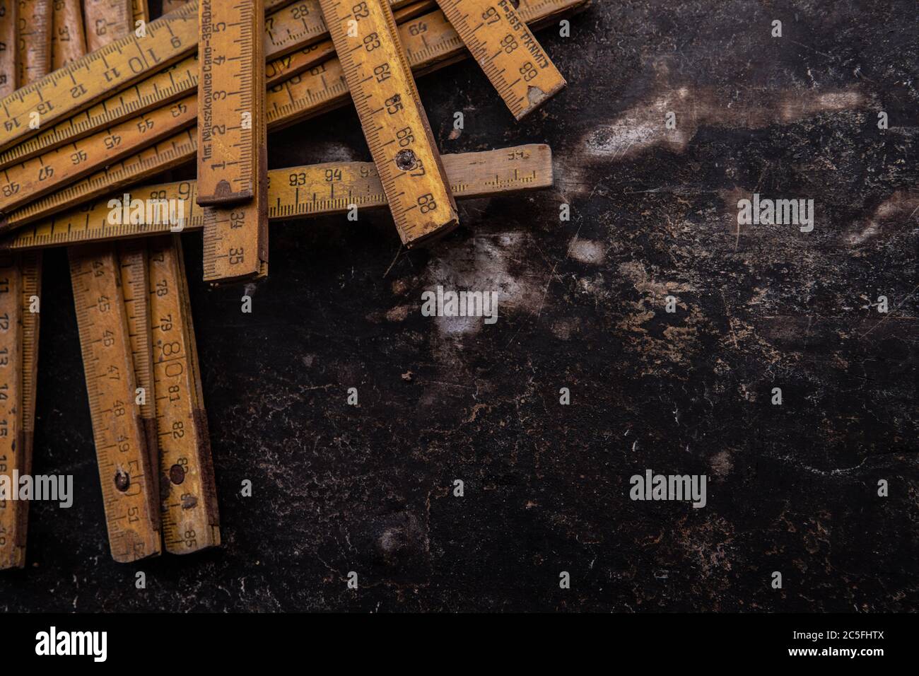 old tools, hammer, chisel, spatula measuring tape and brushes greasy and dirty heavily rusted lie on a metal dark background Stock Photo