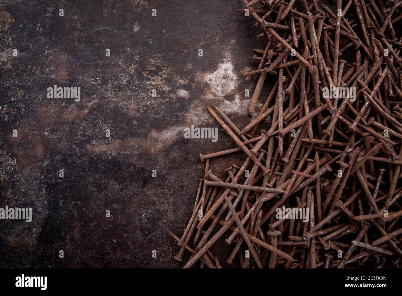 old tools hammer, pliers and nails heavily rusted lie on a metal dark background Stock Photo