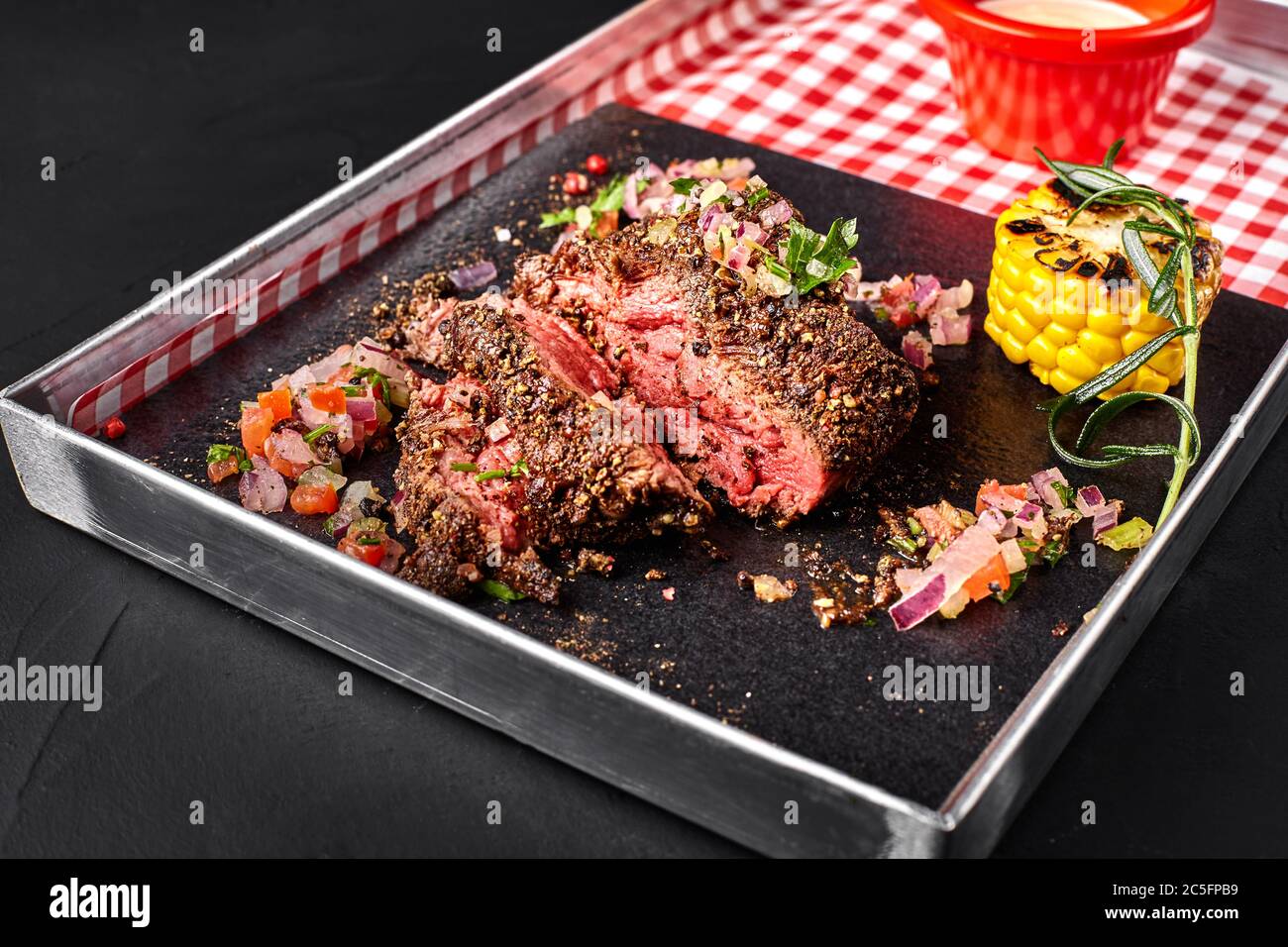 Sliced medium rare grilled Beef steak Ribeye with corn, rosemary, onion