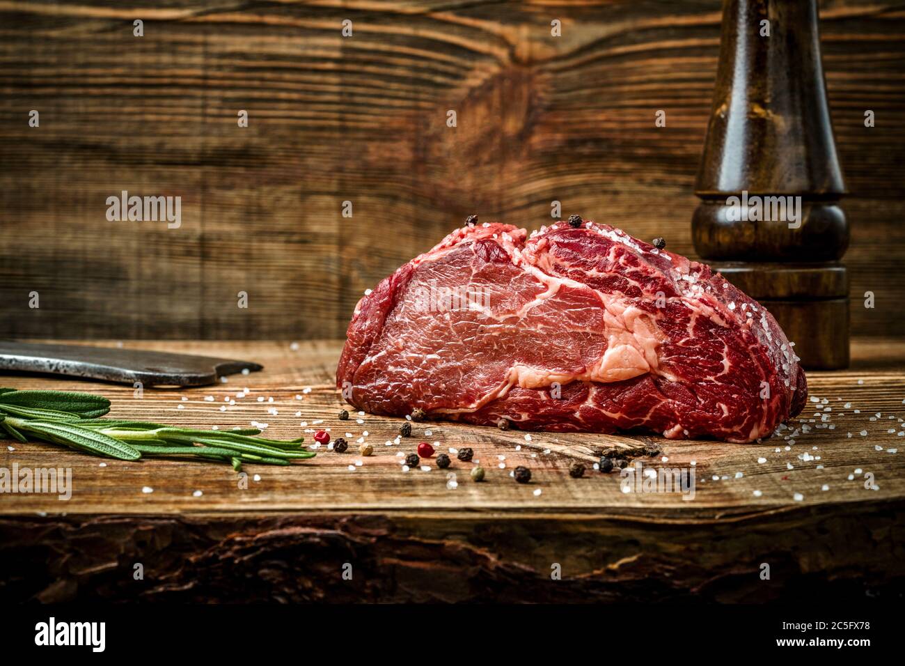 Dry aged Ribeye Steak with seasoning on wooden background Stock Photo