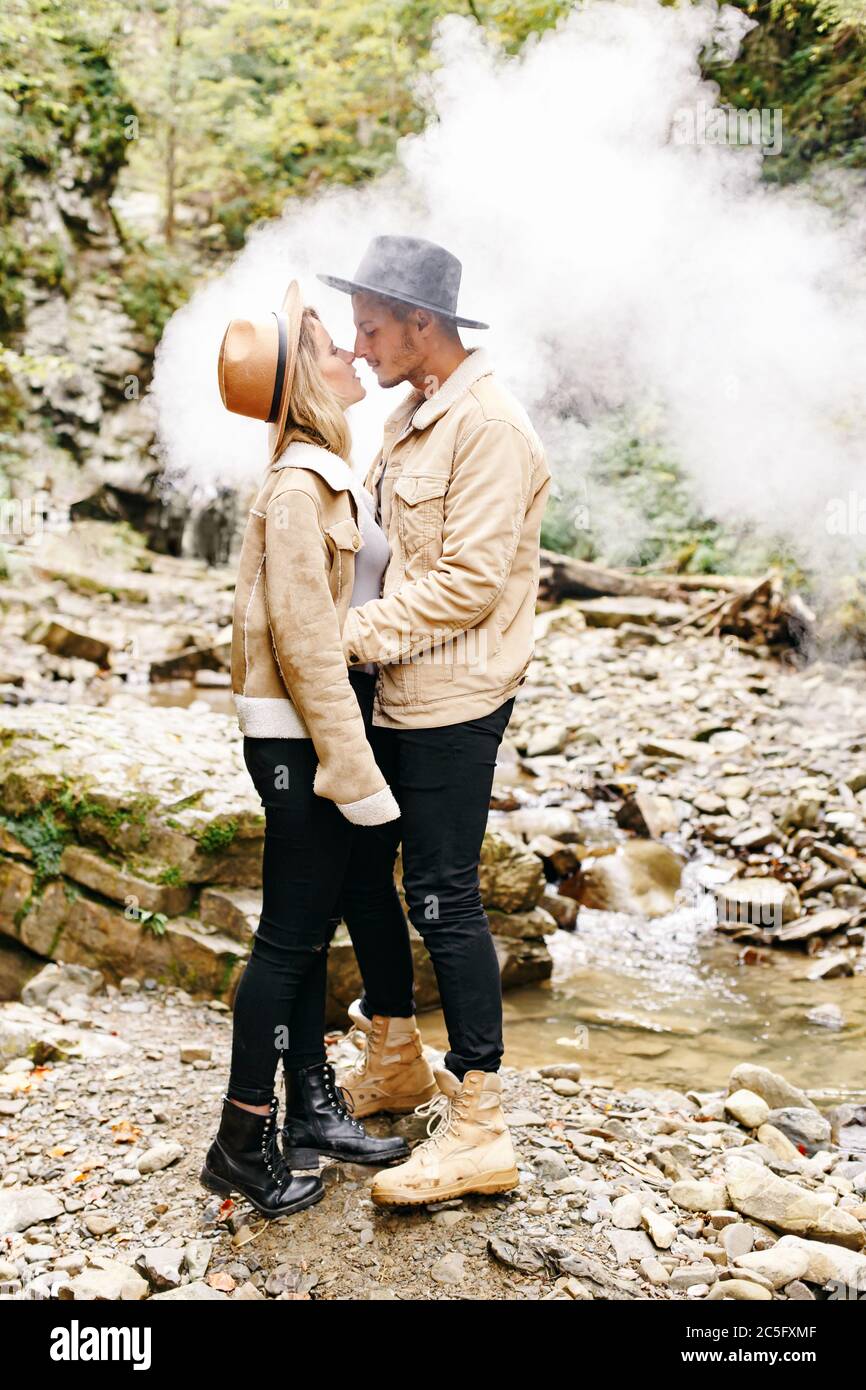 Couple in vape cloud. Two in smoke. Tourists in cold autumn forest with vape.  Man and women in smoke. Two smokers. Beautiful couple in fog. E-cigarett  Stock Photo - Alamy