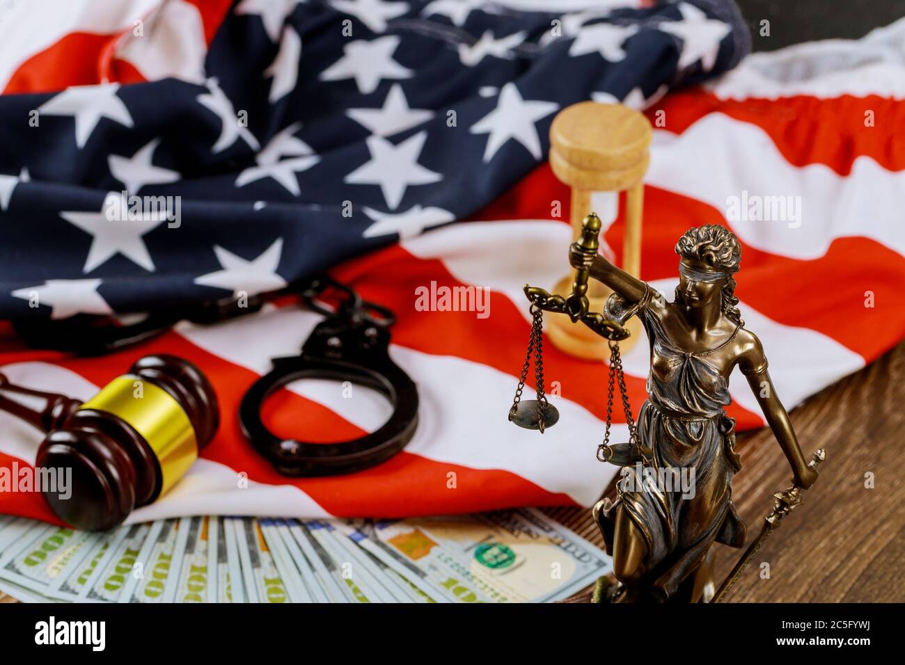 Lawyers desk statue of justice on law in court gavel on blurred USA flag Stock Photo