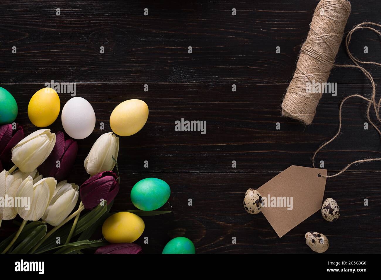 Easter eggs and tulips on dark wooden planks Stock Photo - Alamy