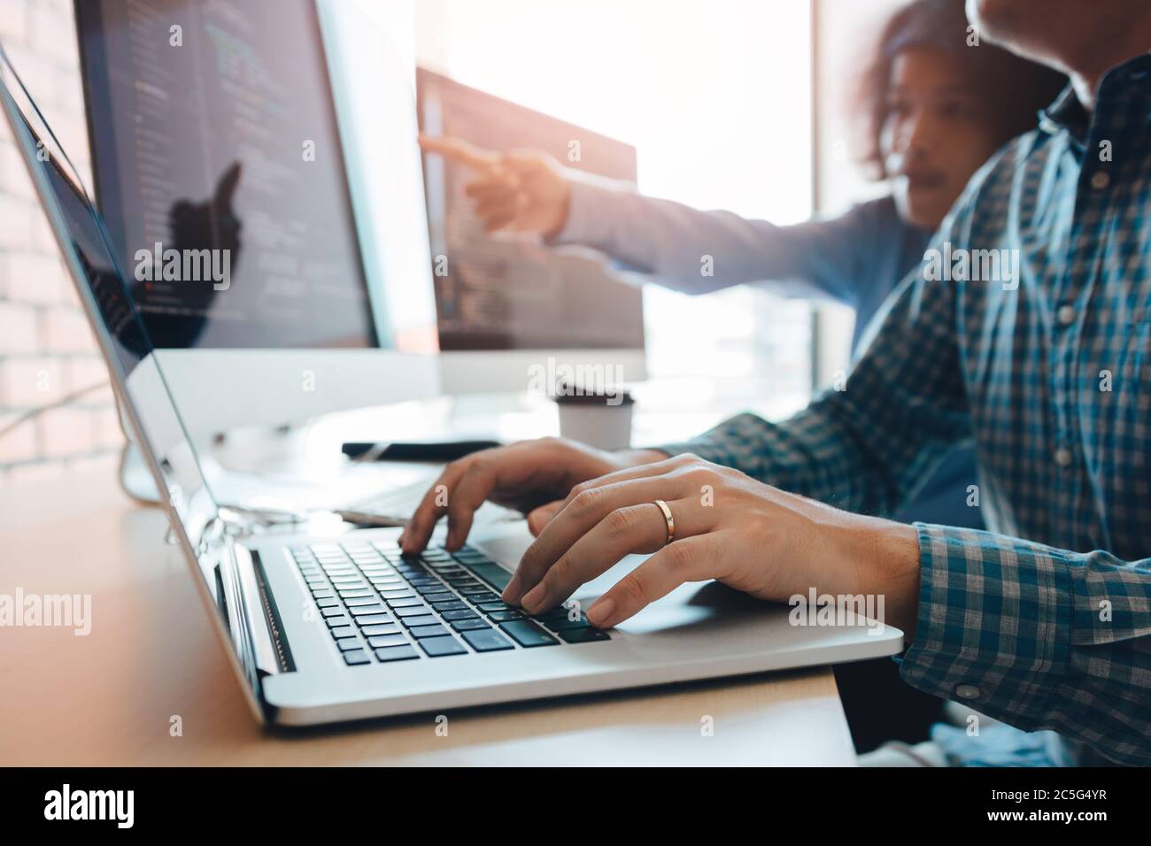 Two partnerships developing programming and coding technologies working on laptop and analyzing together. Stock Photo