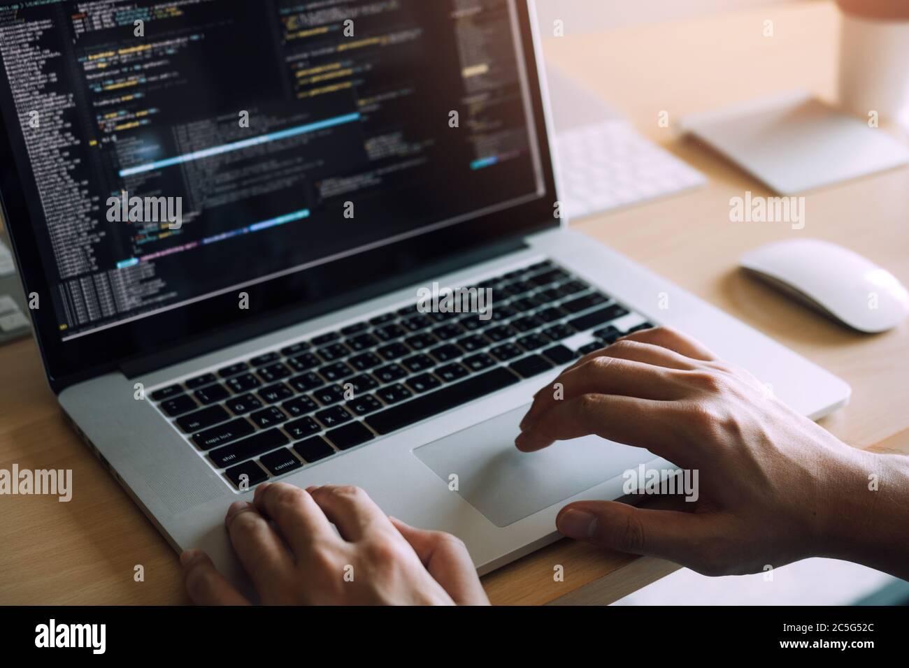 Close up hands of the software developers are sitting serious work analyzing data on the computer screen. Stock Photo