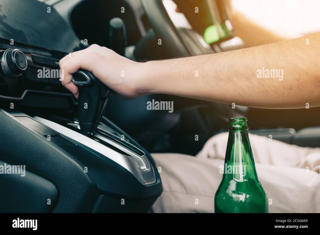 Men are in the car's gear and ready to leave while having a beer bottle