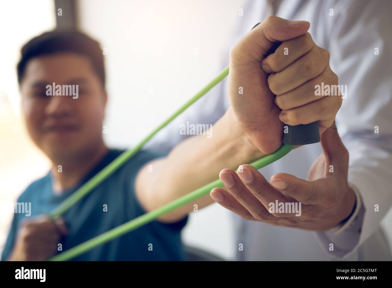 Close up hand patient doing stretching exercise with a flexible