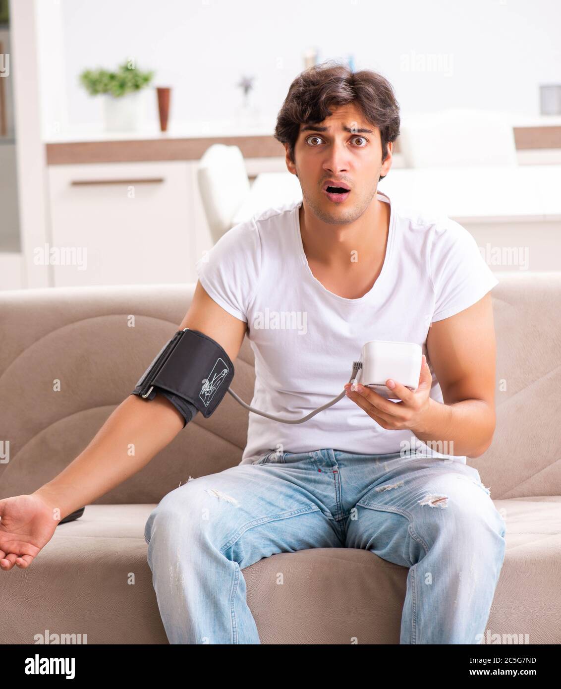 The young man measuring blood pressure at home Stock Photo - Alamy