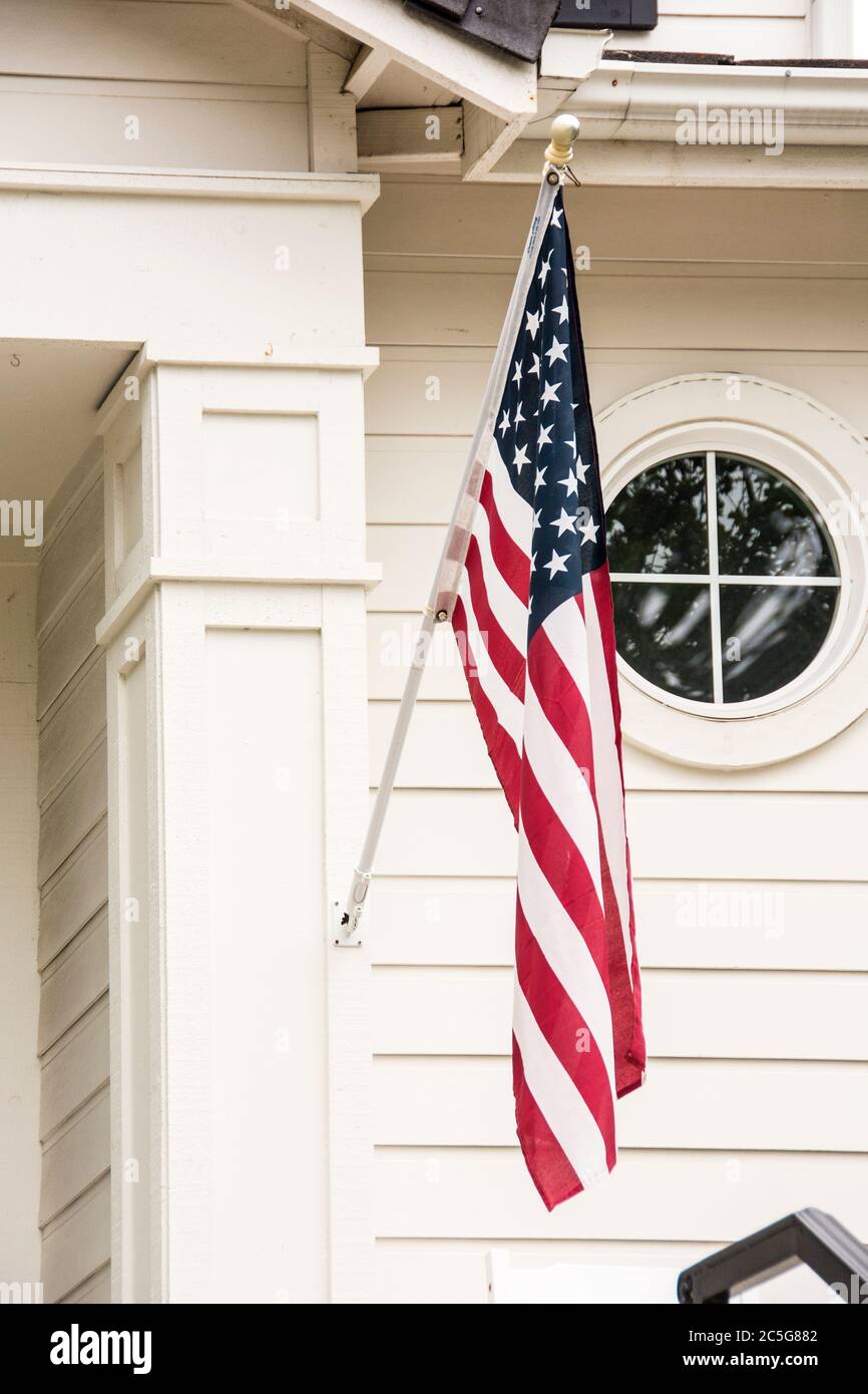 An American flag hanging from the column of a porch at a home in Mission Viejo, California. Stock Photo