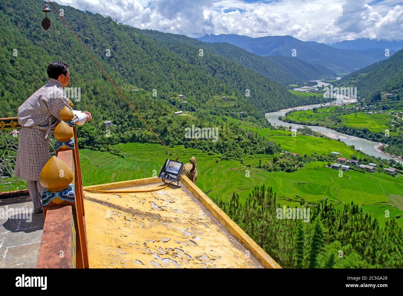 Bhutanese man looking over the Mo Chhu Valley fromthe roof of Khamsum Yuellay Temple in Punakha Stock Photo