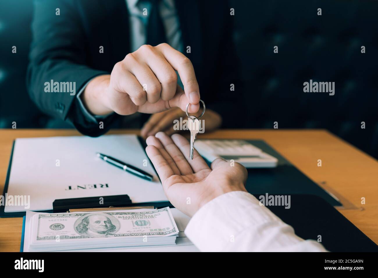 Close up hand of home agents are handing out keys to new home buyers ...