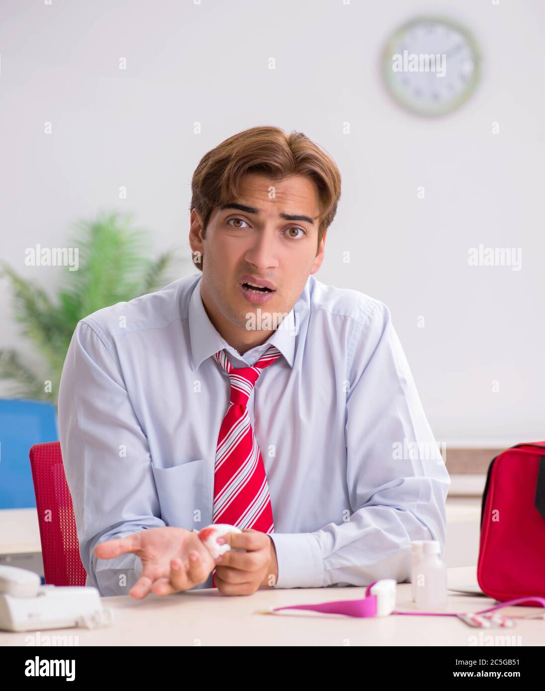 The man with first aid kit in the office Stock Photo - Alamy