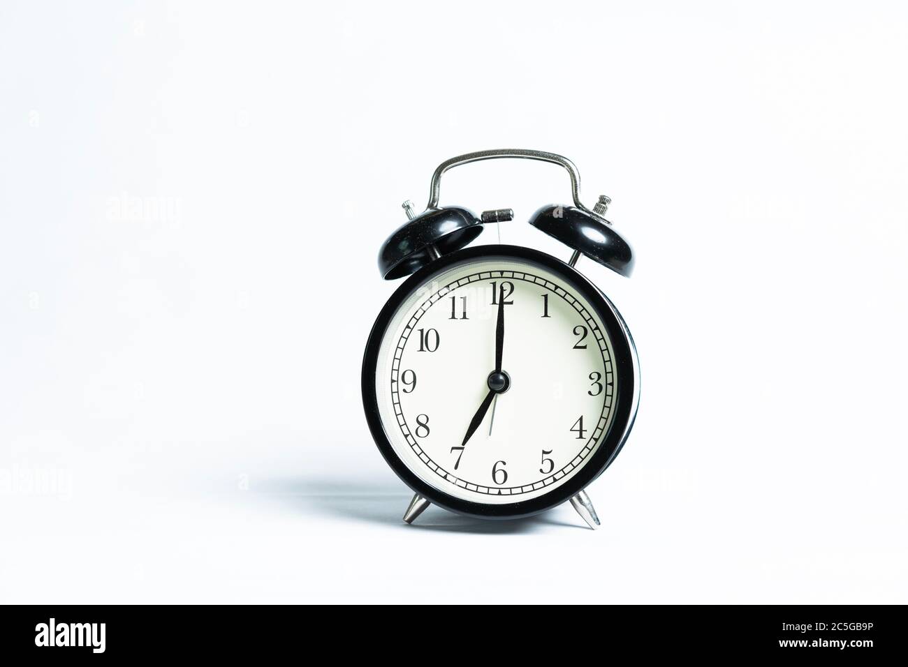 A black alarm clock isolated against white background Stock Photo - Alamy