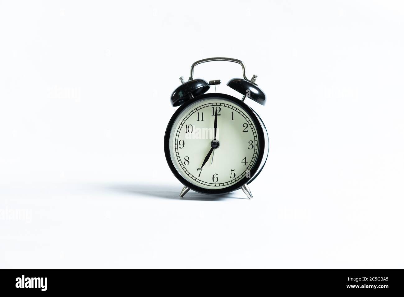 A black alarm clock isolated against white background Stock Photo - Alamy