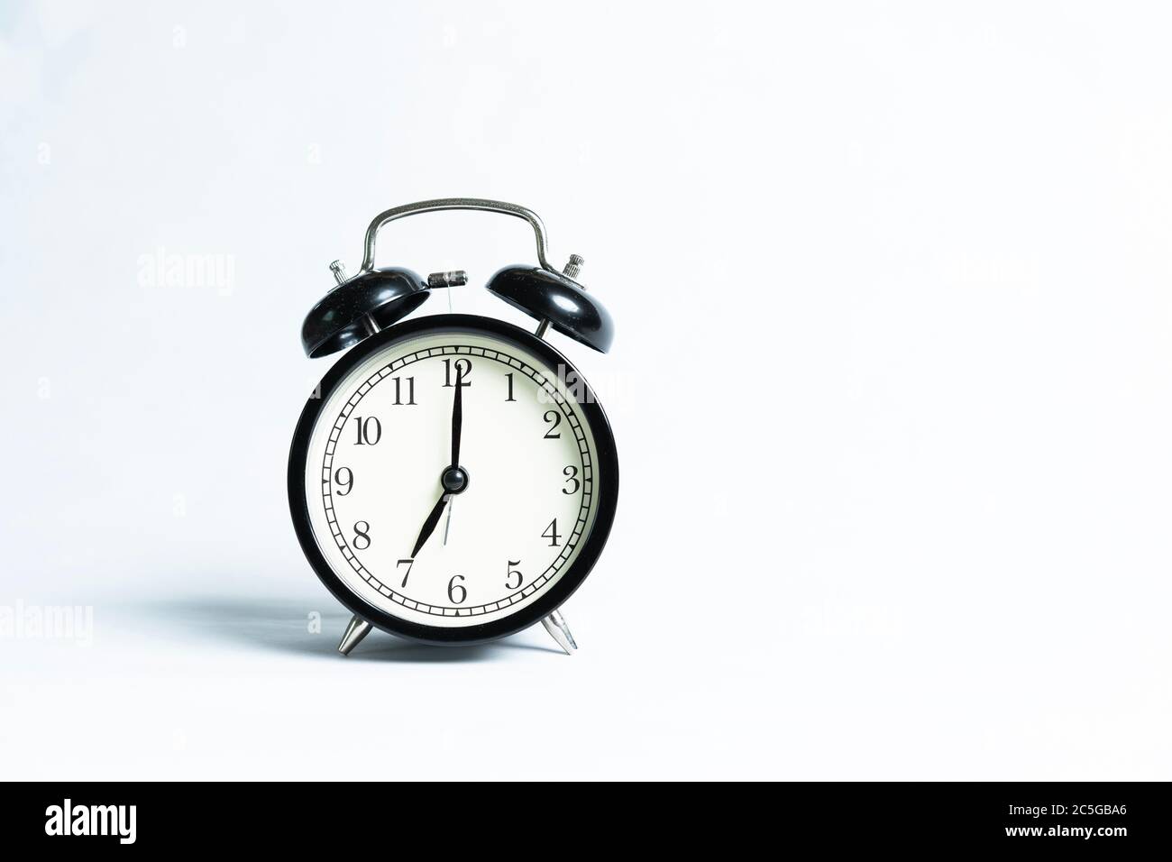 A black alarm clock isolated against white background Stock Photo - Alamy
