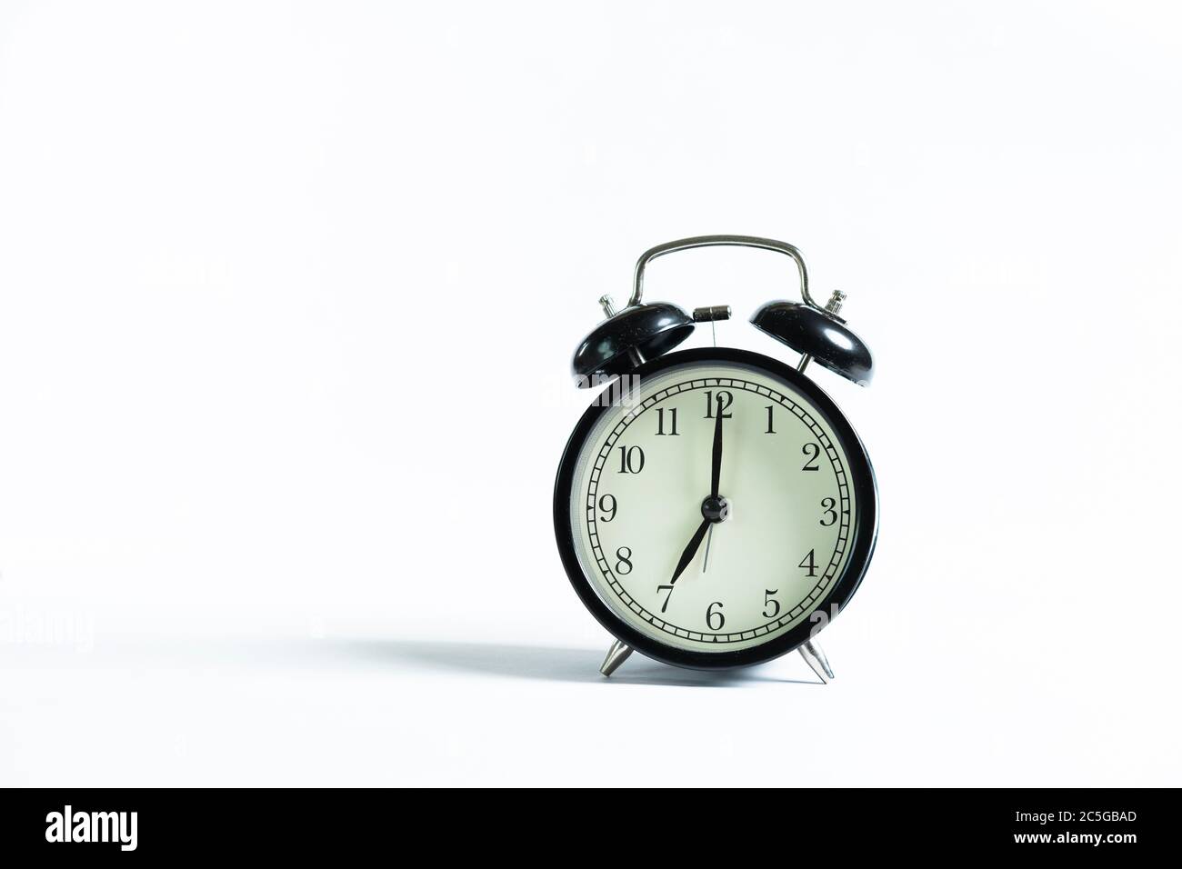 A black alarm clock isolated against white background Stock Photo - Alamy