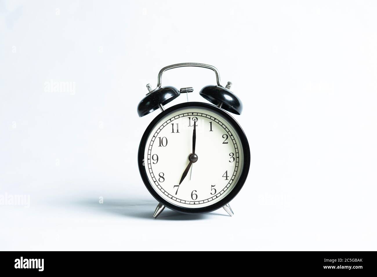 A black alarm clock isolated against white background Stock Photo - Alamy