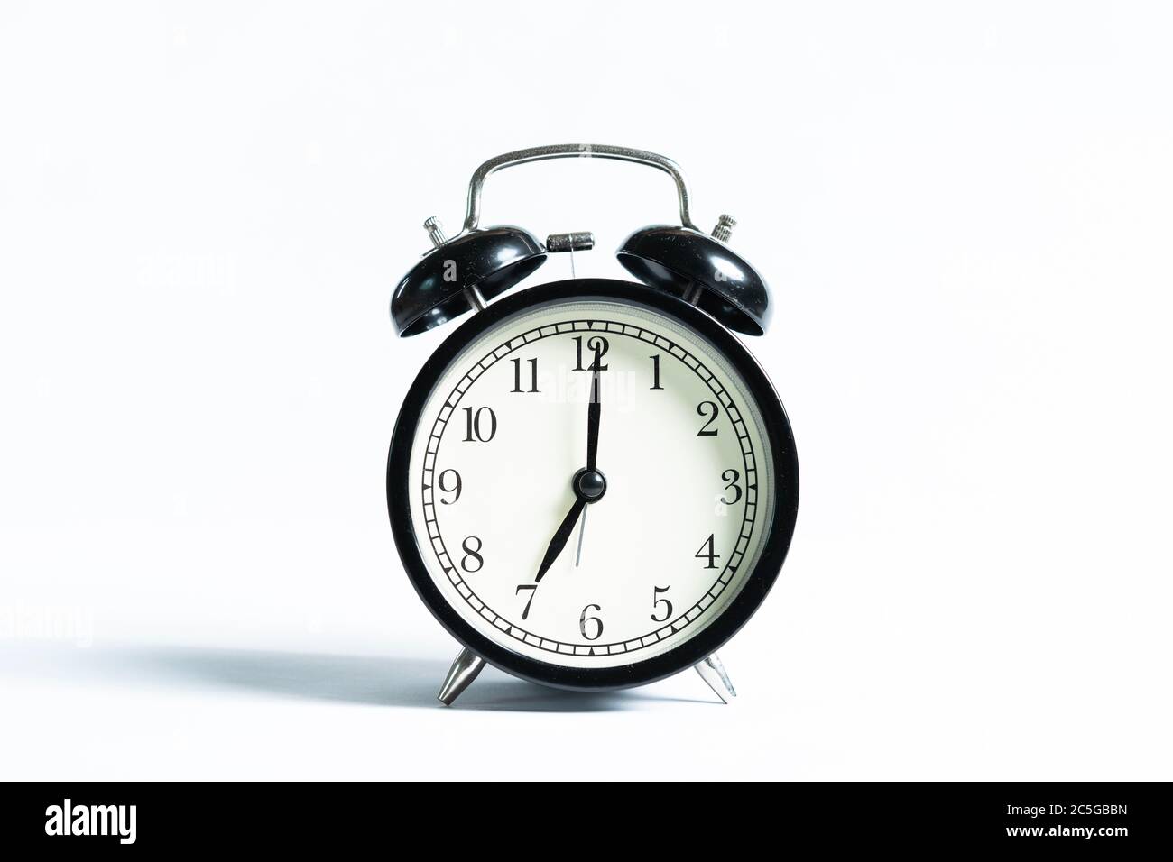A black alarm clock isolated against white background Stock Photo - Alamy