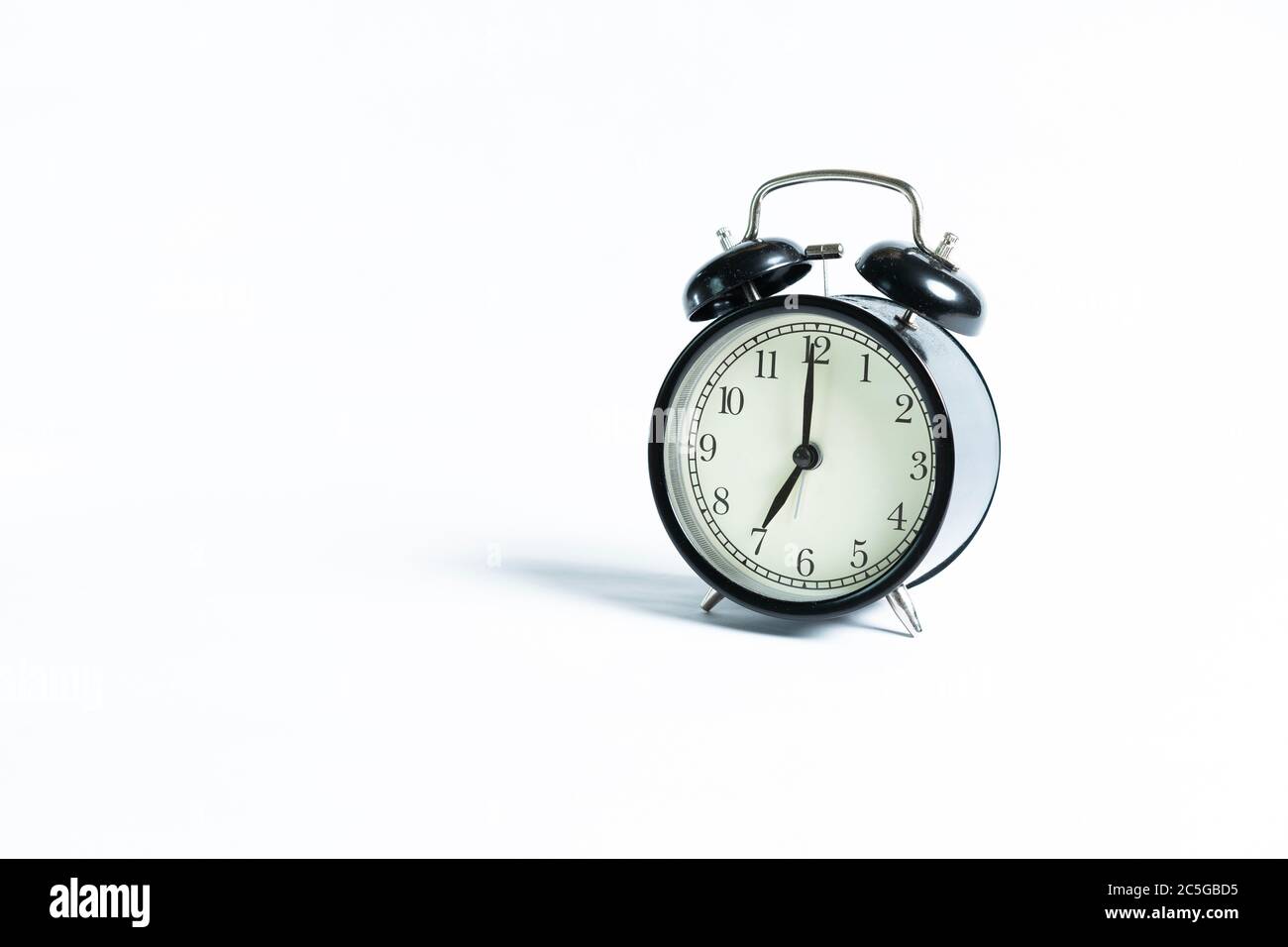 A black alarm clock isolated against white background Stock Photo - Alamy