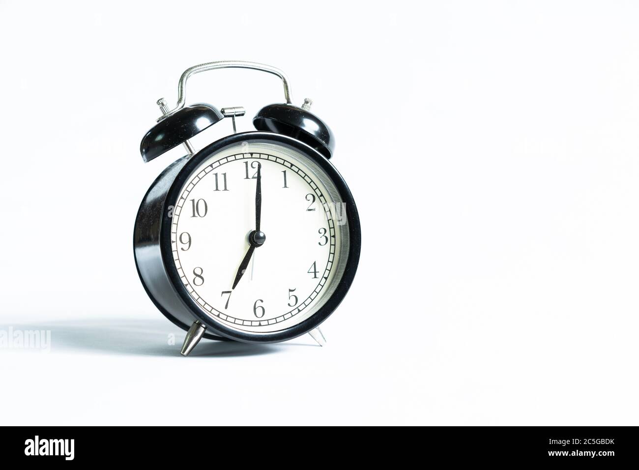 A black alarm clock isolated against white background Stock Photo - Alamy