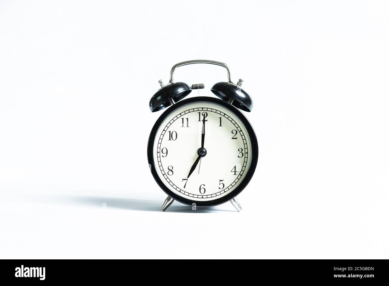 A black alarm clock isolated against white background Stock Photo - Alamy