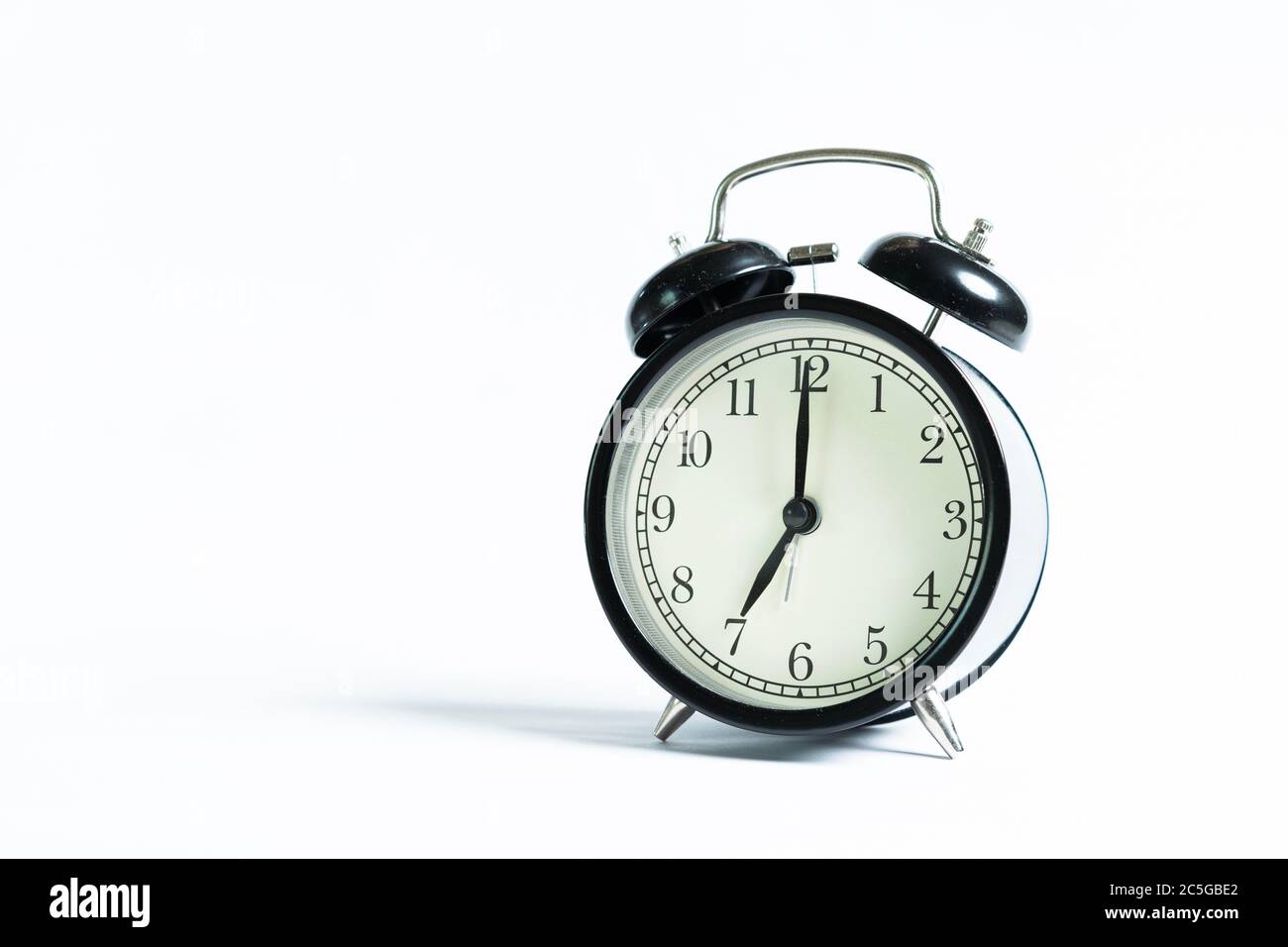 A black alarm clock isolated against white background Stock Photo - Alamy