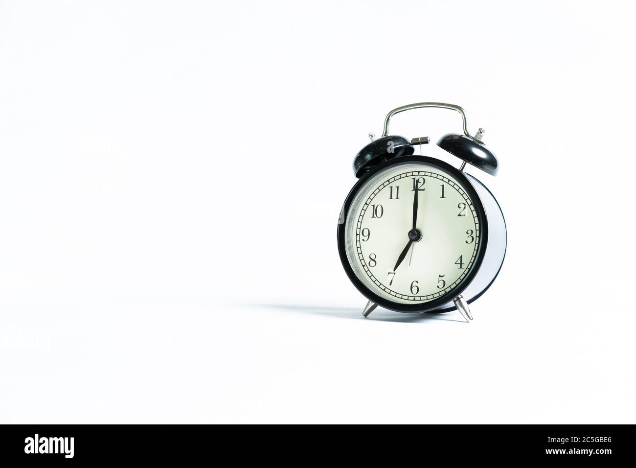 A black alarm clock isolated against white background Stock Photo - Alamy