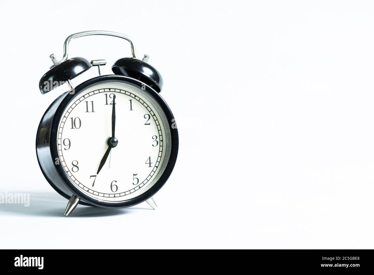 A black alarm clock isolated against white background Stock Photo - Alamy
