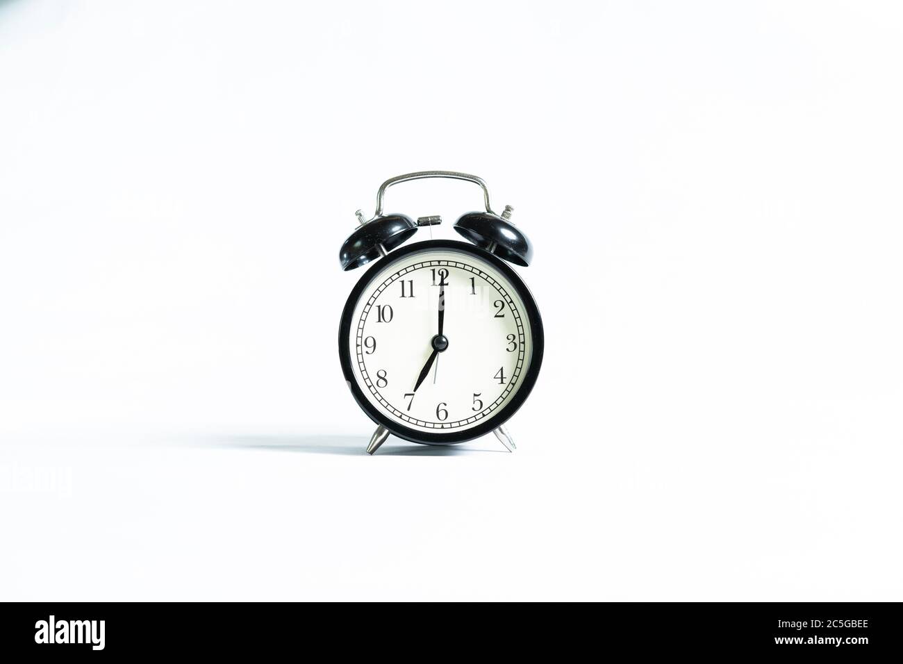 A black alarm clock isolated against white background Stock Photo - Alamy