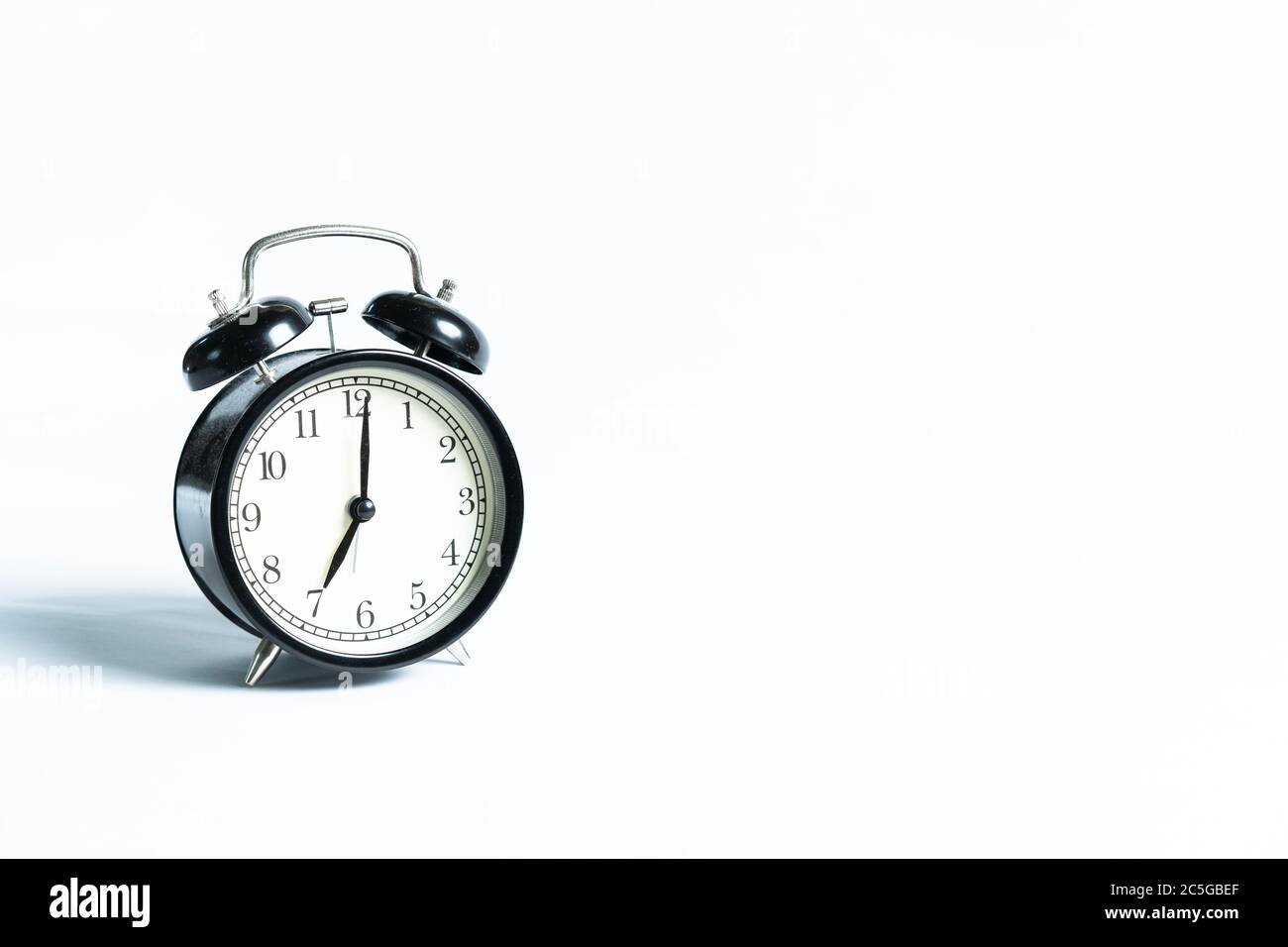 A black alarm clock isolated against white background Stock Photo - Alamy