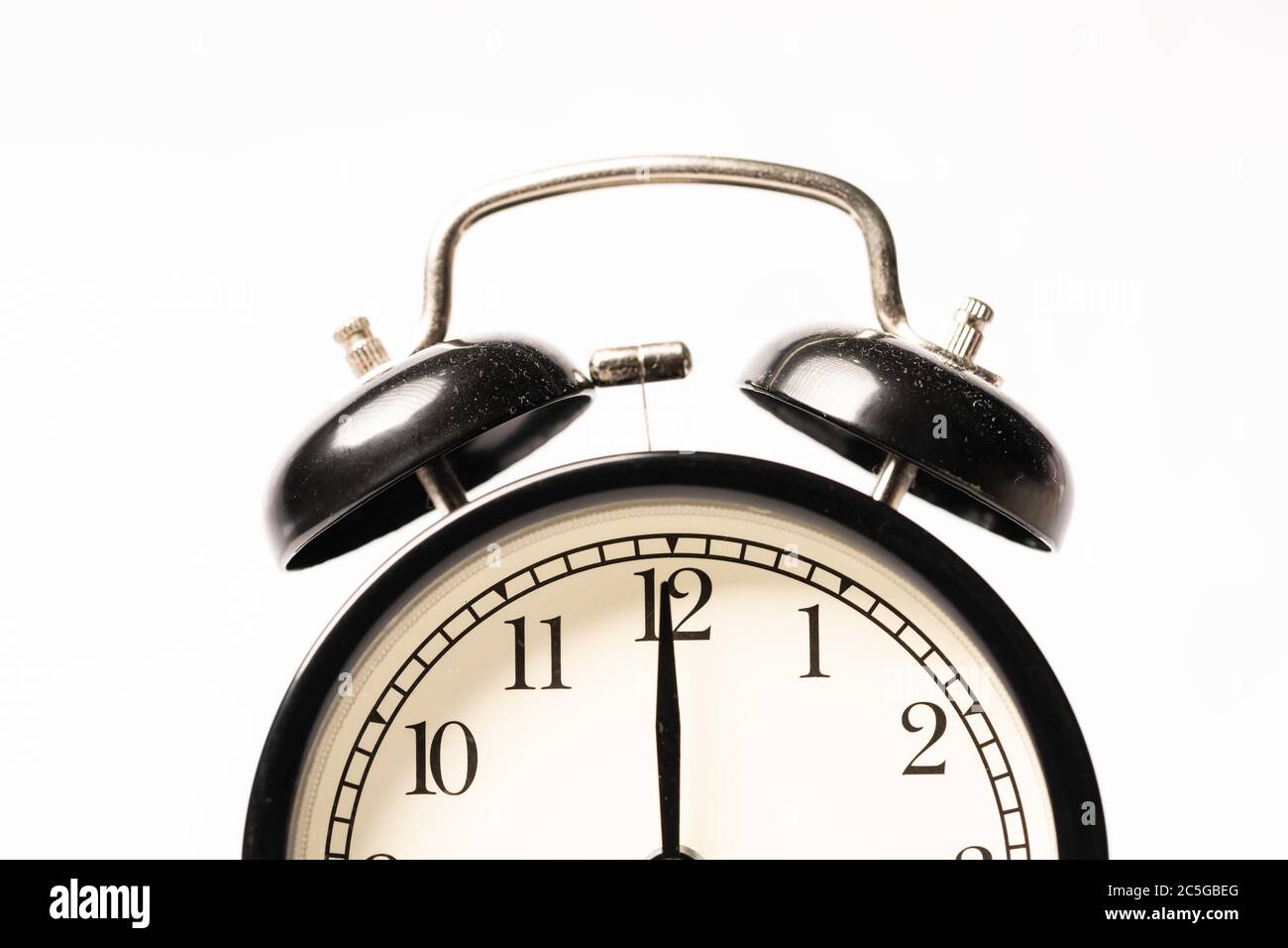 A black alarm clock isolated against white background Stock Photo - Alamy
