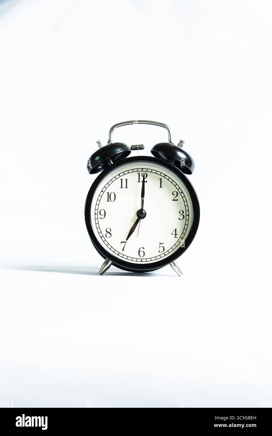 A black alarm clock isolated against white background Stock Photo - Alamy