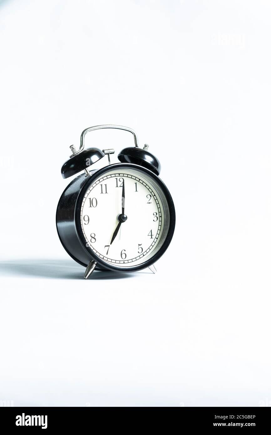 A black alarm clock isolated against white background Stock Photo - Alamy