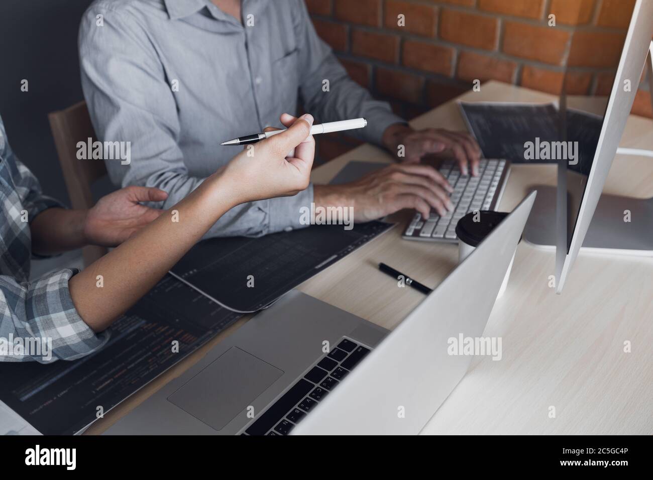 Developing programming and coding technologies working in a software engineers developing applications together in office. Stock Photo