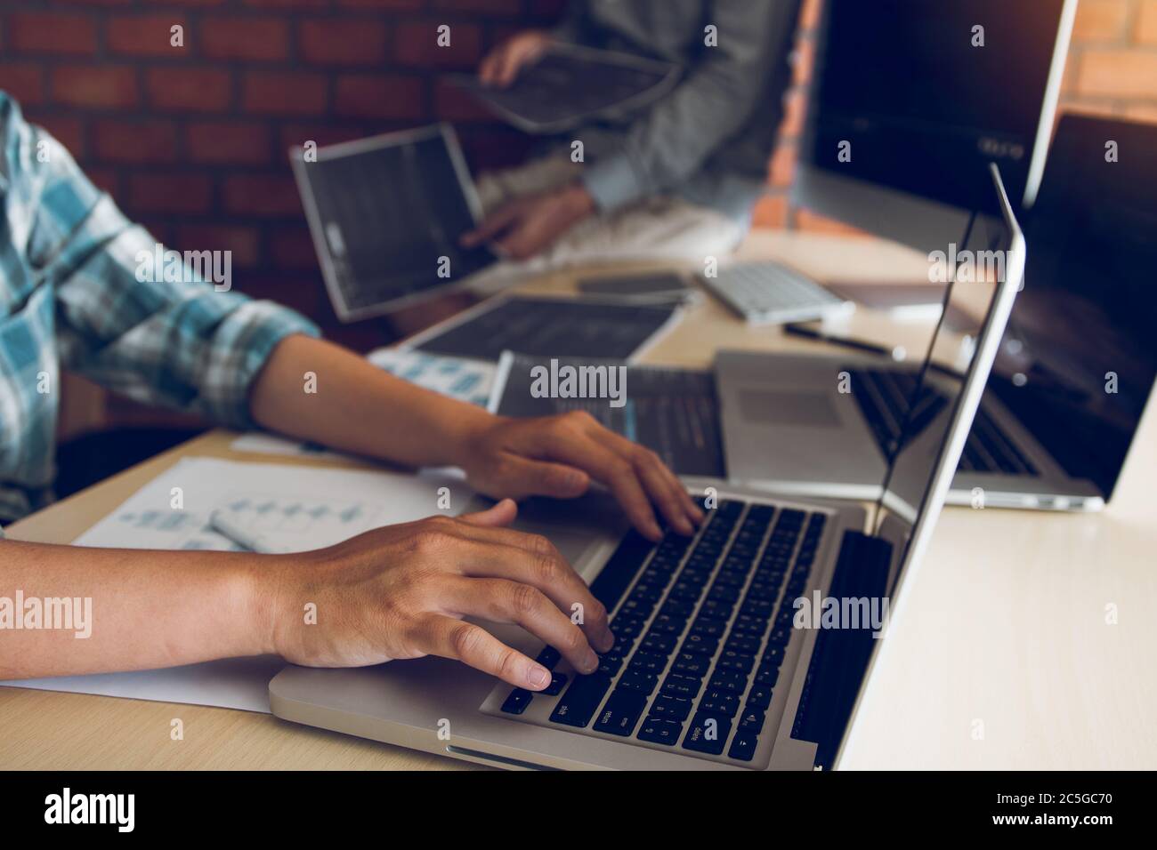 Two software developers are analyzing together about the code written into the program on the computer. Stock Photo