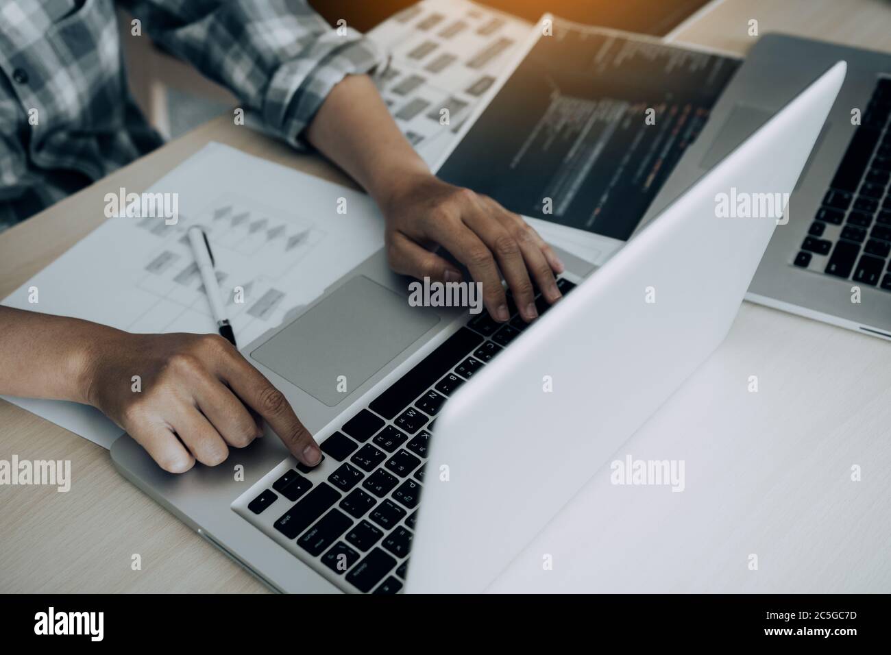 Two software developers are analyzing together about the code written into the program on the computer. Stock Photo