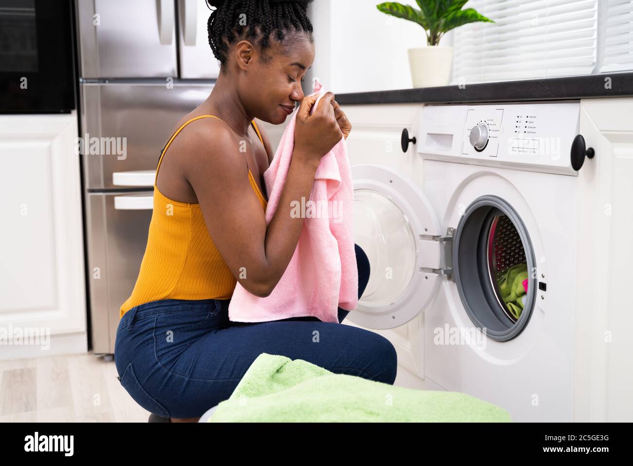 Smelling Washed Clothes Or Laundry At Home Stock Photo