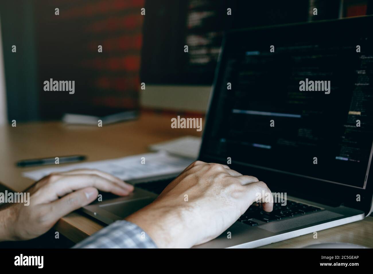 Close up hands of the software developers are sitting serious work analyzing data on the computer screen. Stock Photo