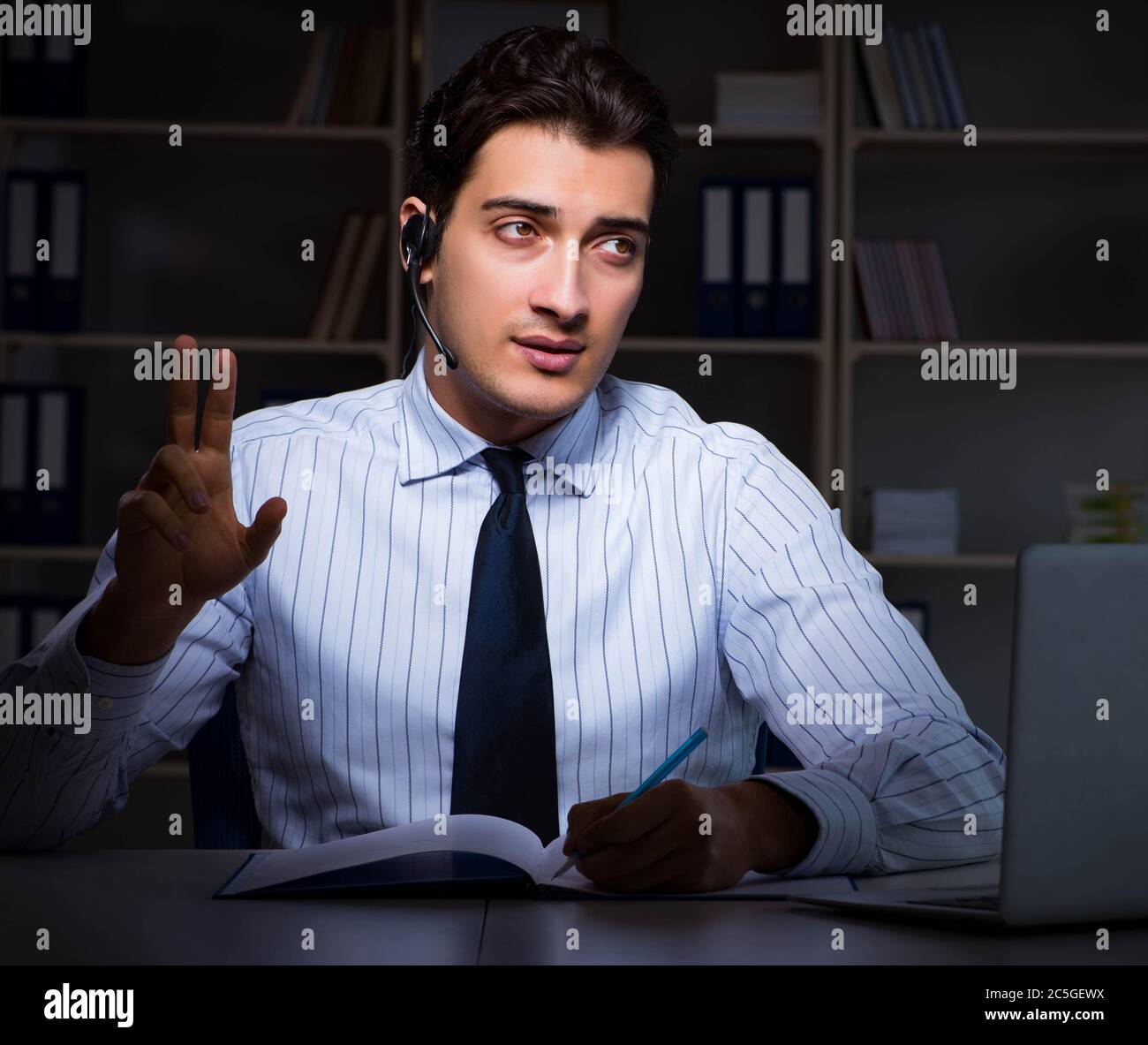 The call center operator talking to customer during night shift Stock