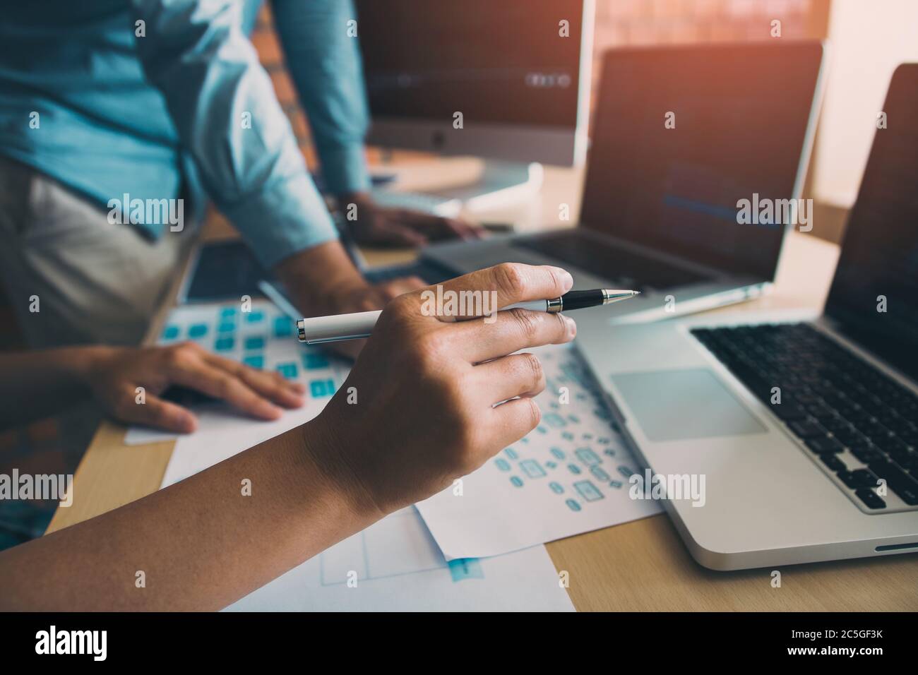 Two software developers are analyzing together about the code written into the program on the computer. Stock Photo