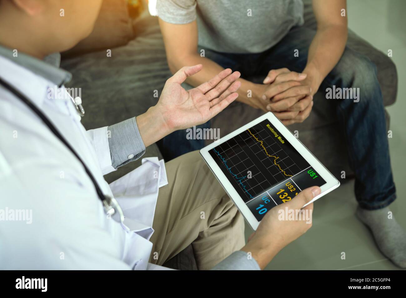Asian doctor visited the patient at home while using the tablet ...