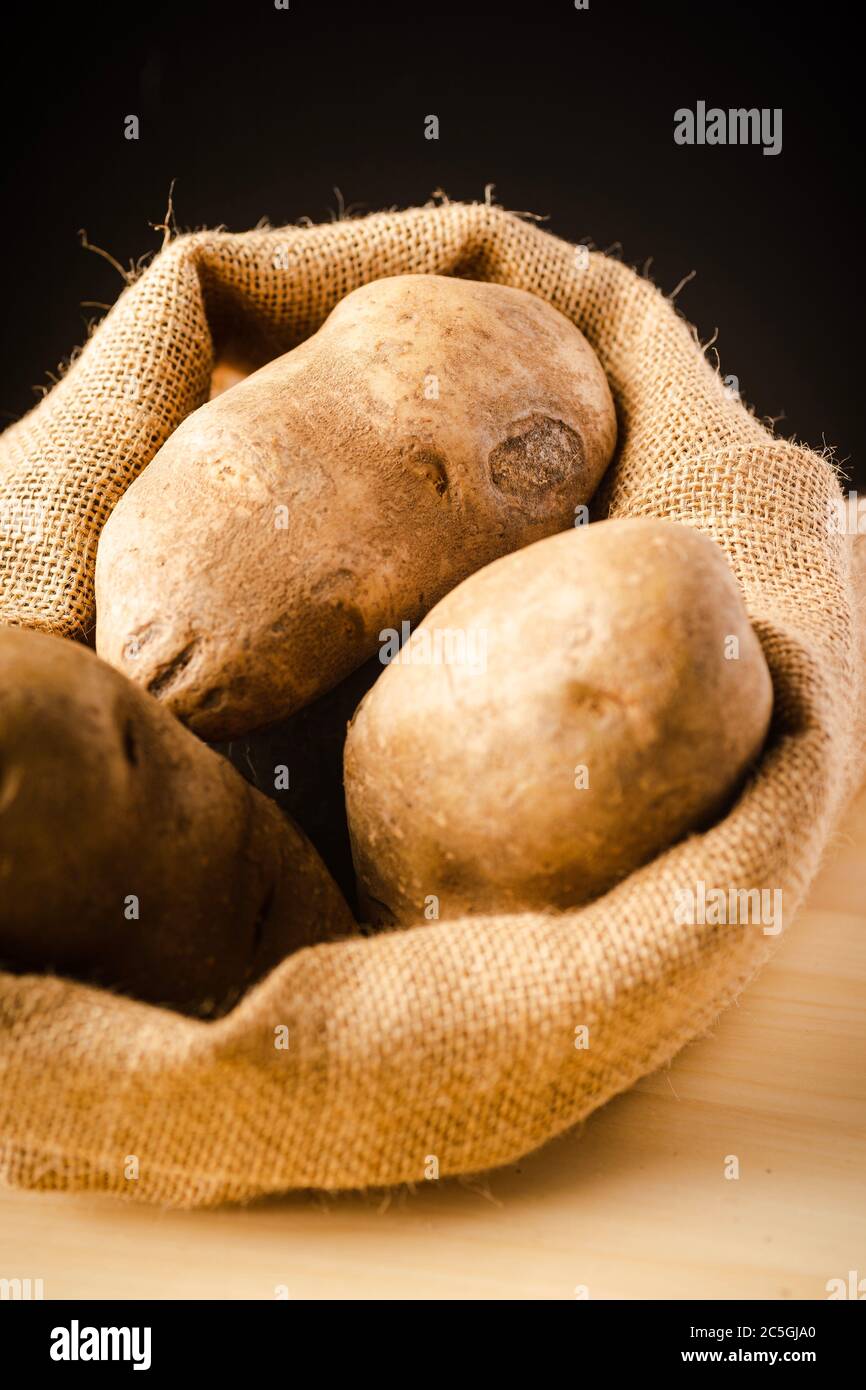 Fresh Potatoes on a rag with dark background Stock Photo - Alamy